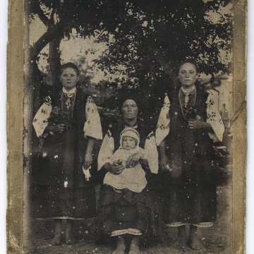 Жінка з немовлям на руках та дві дівчини у народному вбранні