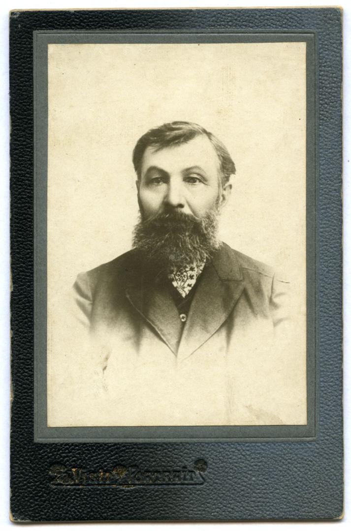 Photo. A headshot of portait of a bearded man