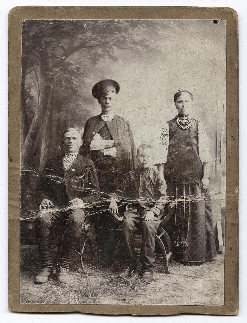 Жінка у народному вбранні, двоє чоловіків та хлопчик  