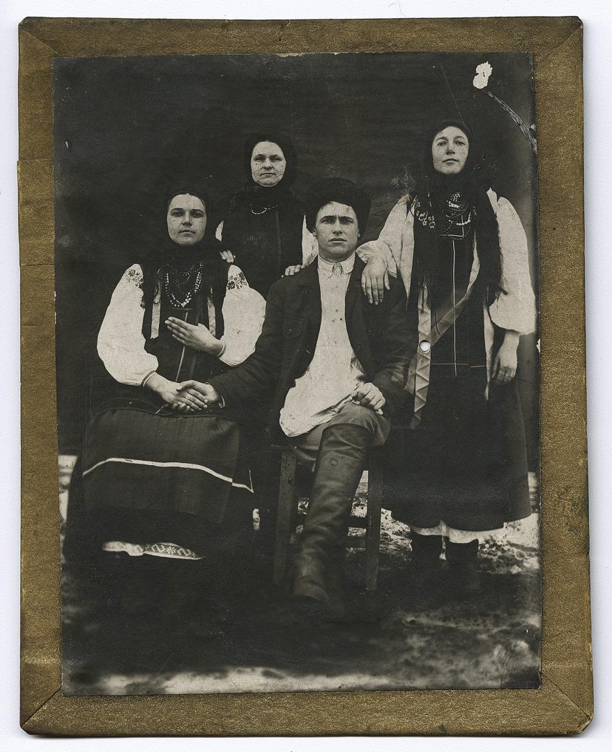 Три жінки у народному вбранні та чоловік