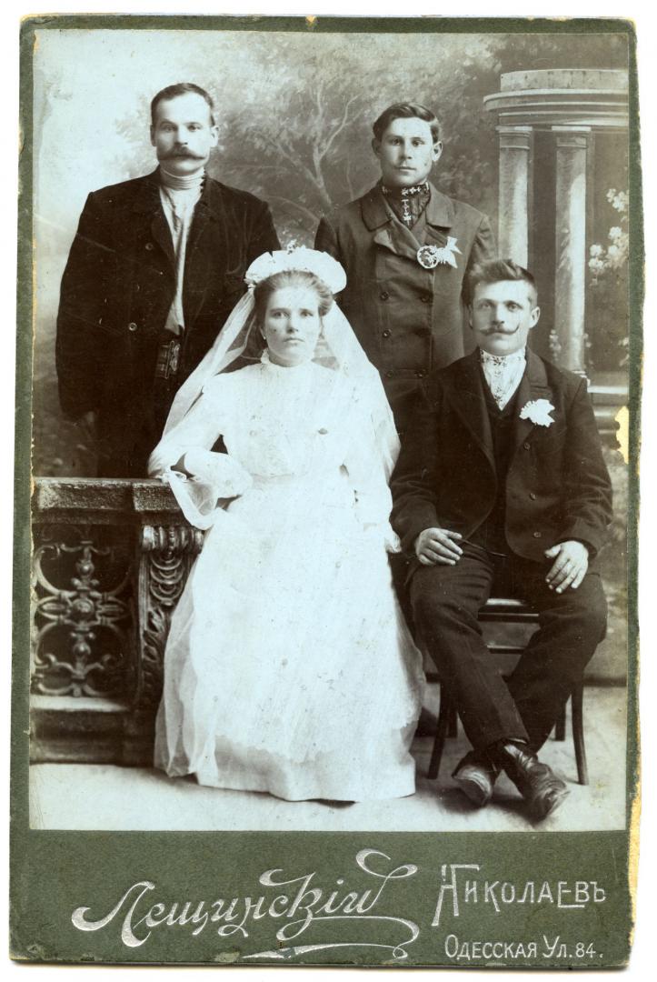 Photo. A bride and a groom, and two men