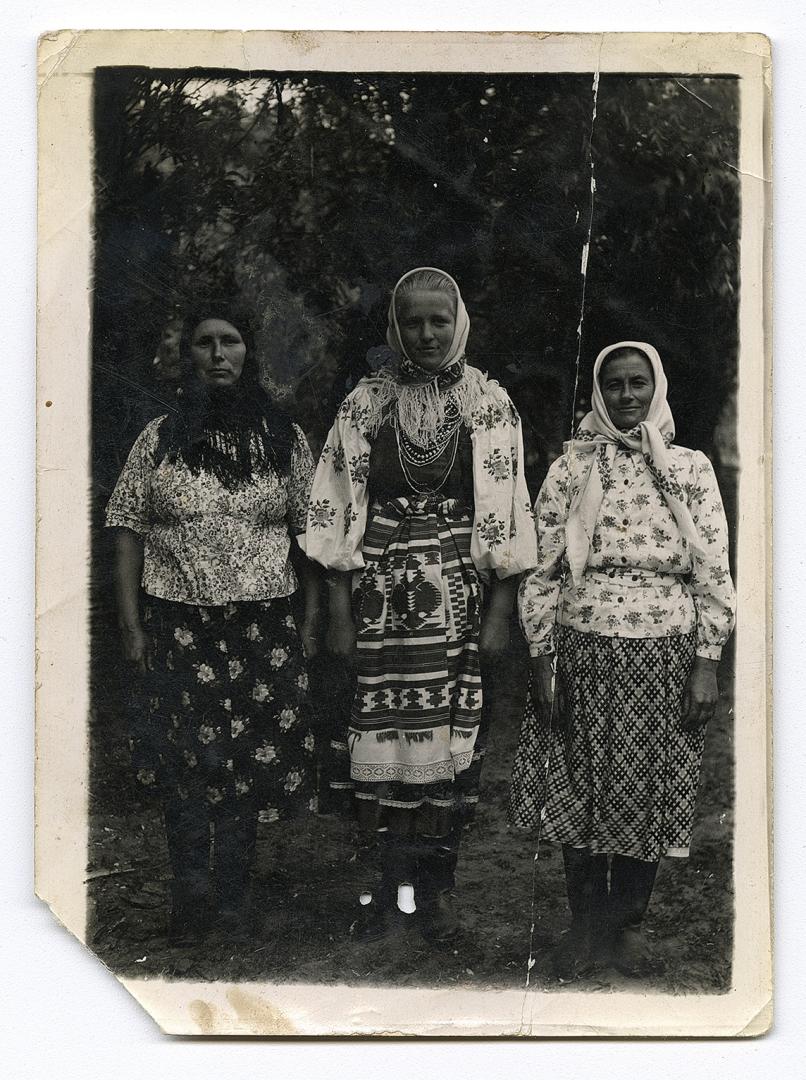 Three women, one in traditional attire and belted with a rushnyk