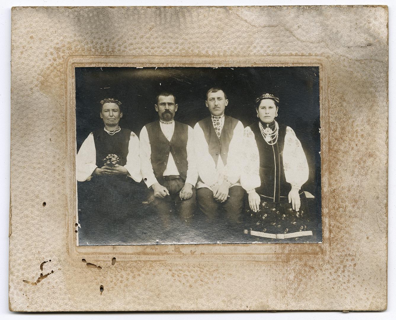 Two women in traditional attire and two men in embroidered shirts and vests