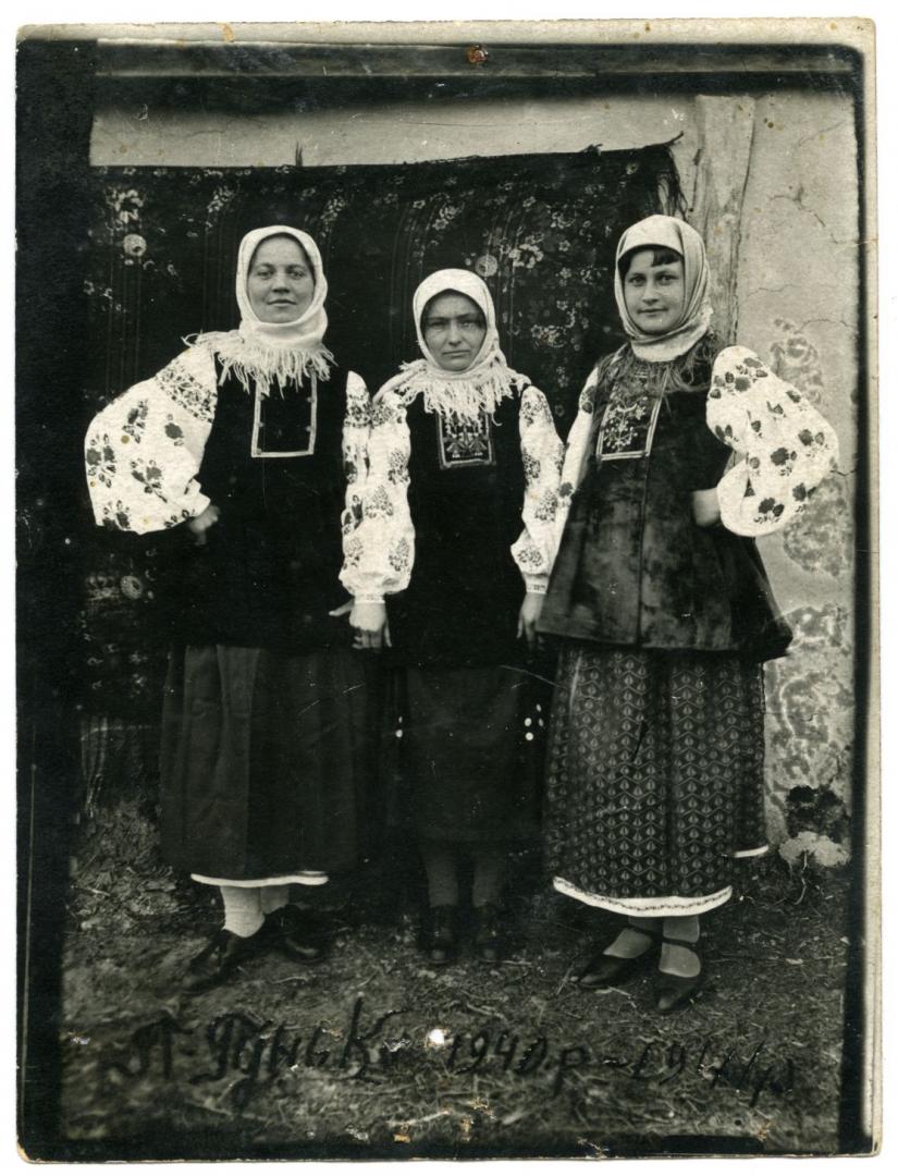 Photo. Three young women wearing embroidered shirts and light-coloured scarves