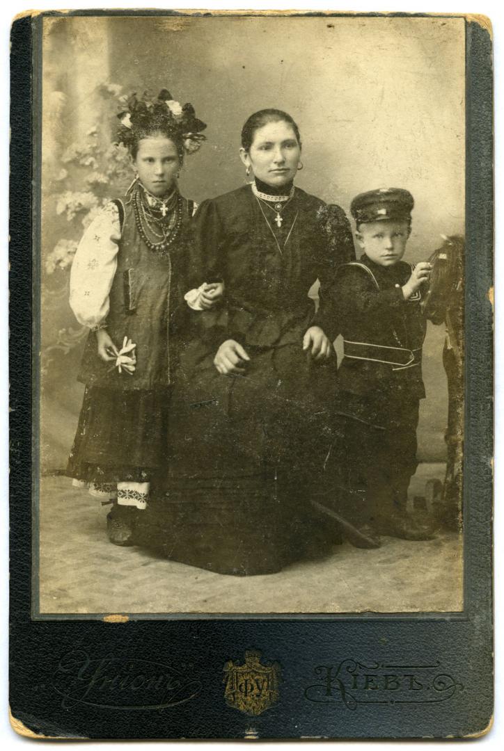 Photo. A young woman, a girl, and a boy wearing urban upper-middle class attire