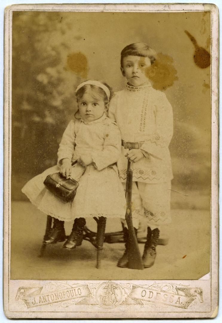 Photo. A girl wearing a light dress and a boy wearing an embroidered suit