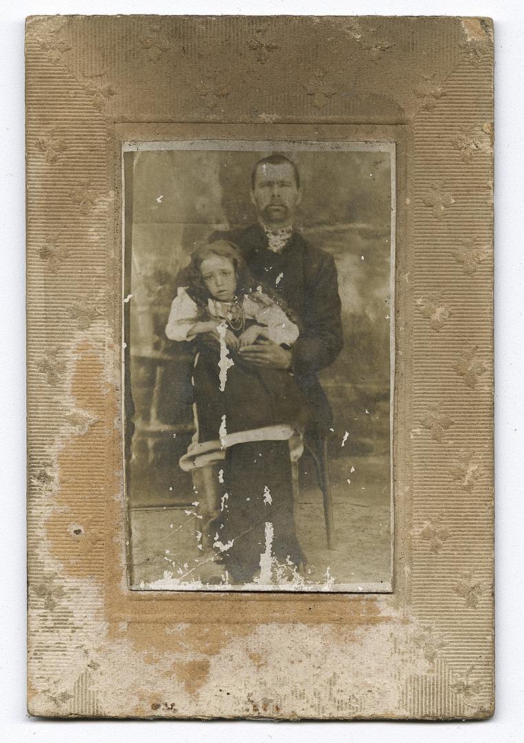 Чоловік у вишитій сорочці із дівчинкою на руках