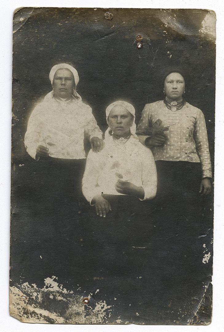 Three women wearing traditional jewelry