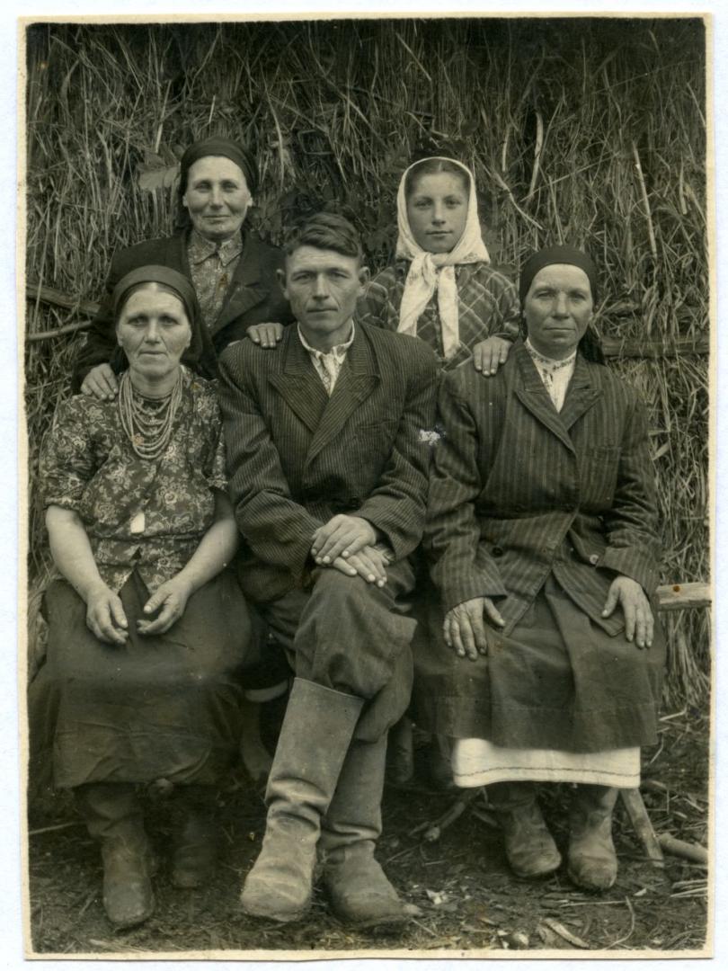Photo. A family standing near a haystack