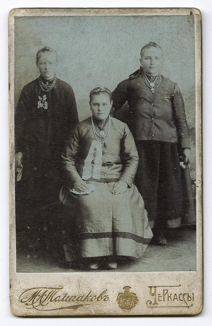 Three girls wearing multi-row bead necklaces