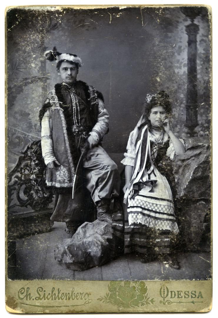Photo. A young girl and a man wearing stylised folk attire