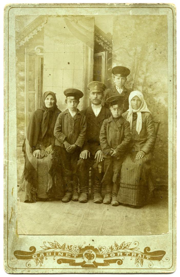 Photo. A family wearing rural folk and and urban upper-middle class attire
