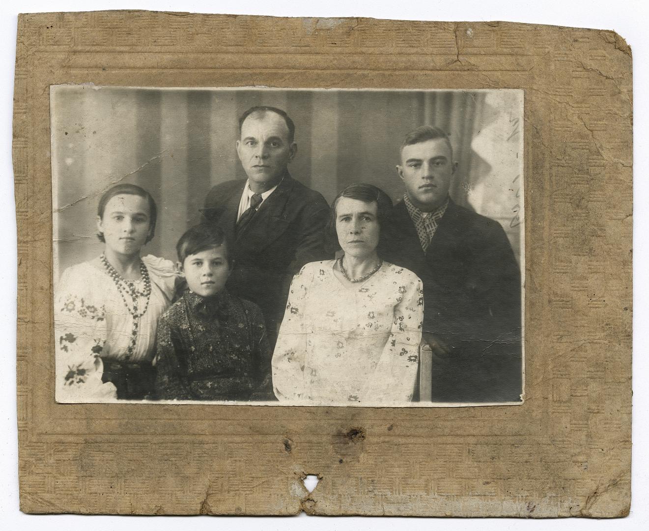 Woman, girl in an embroidered shirt, boy, and two men