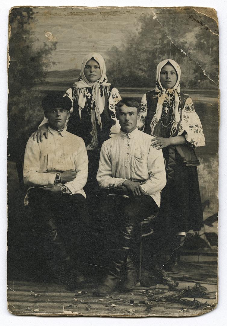 Двоє чоловіків, один у вишитій сорочці, та дві жінки у народному вбранні  