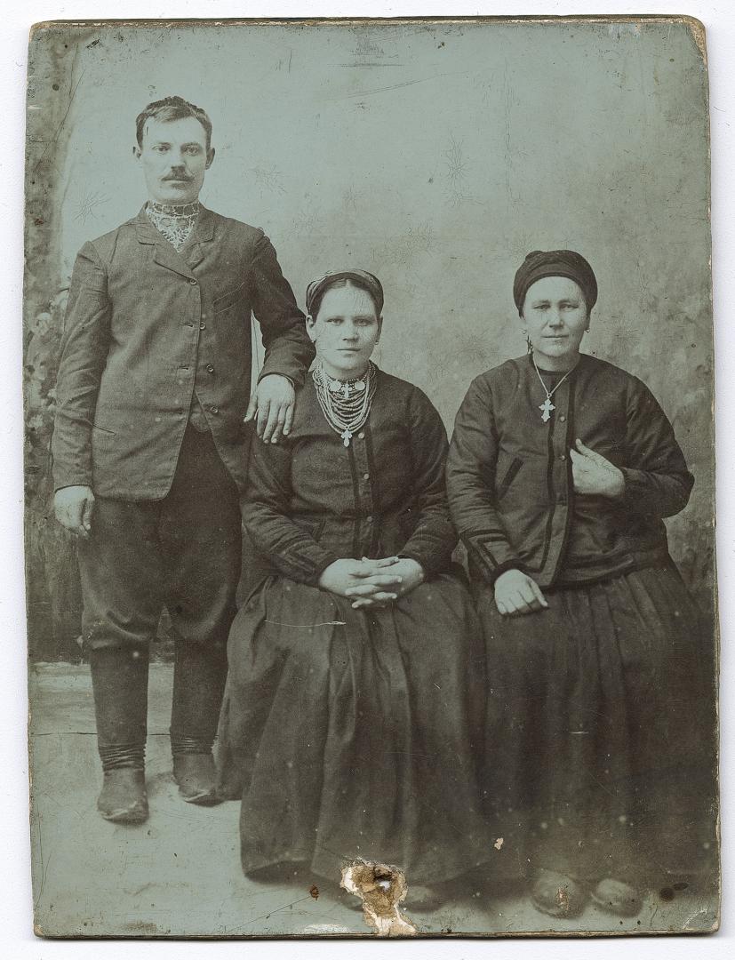 Чоловік у вишитій сорочці та дві жінки у народному вбранні