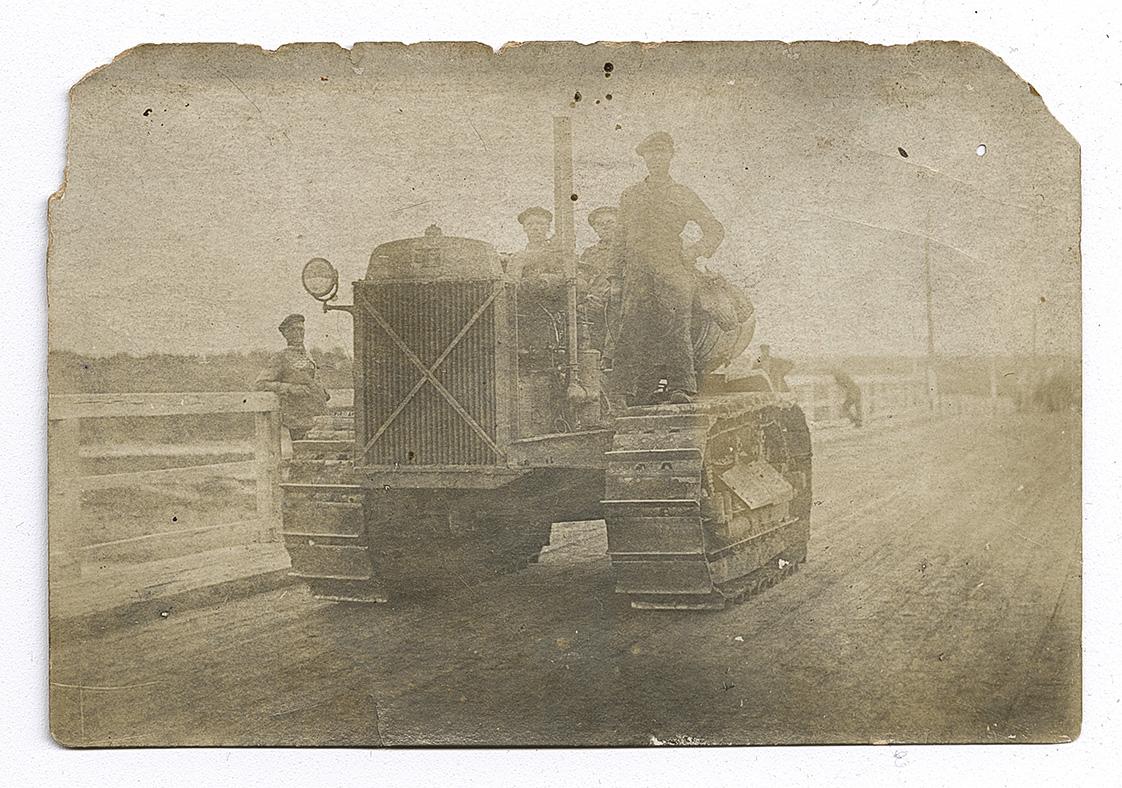 Three men on a crawler tractor