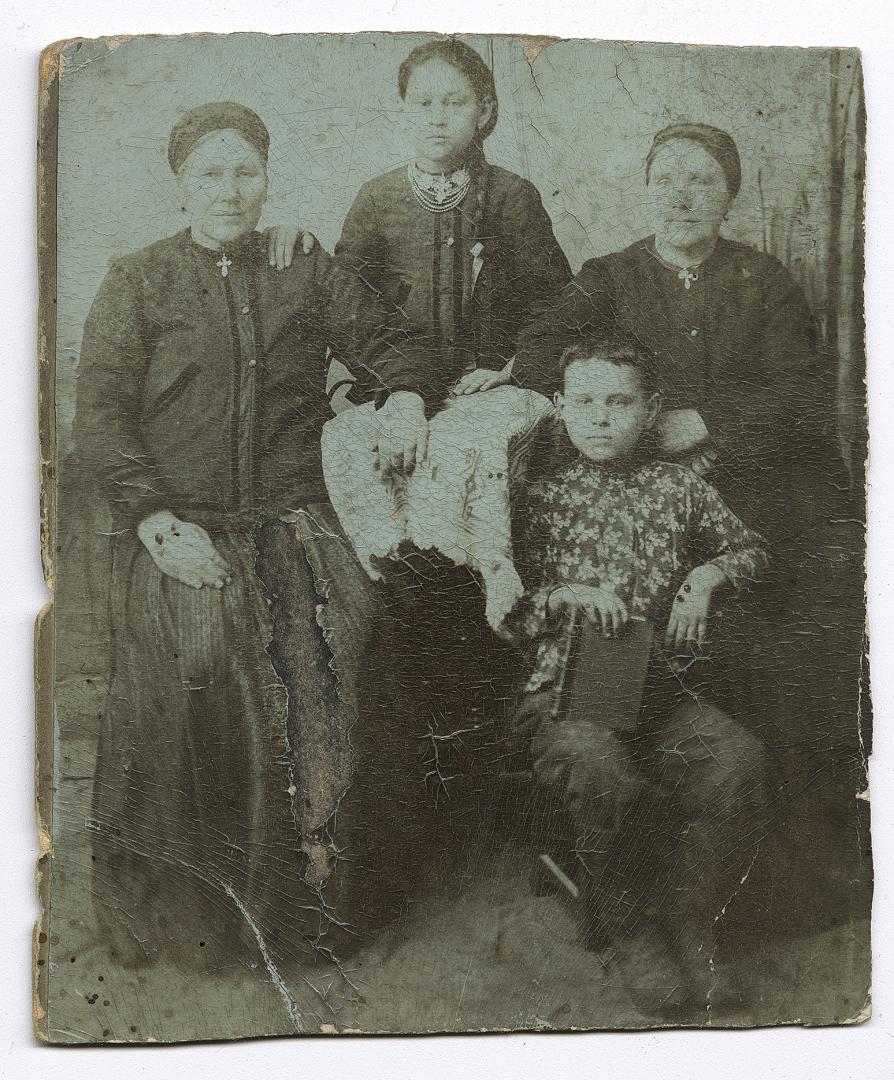 Дві жінки і дівчина у народному вбранні та хлопчик із книгою