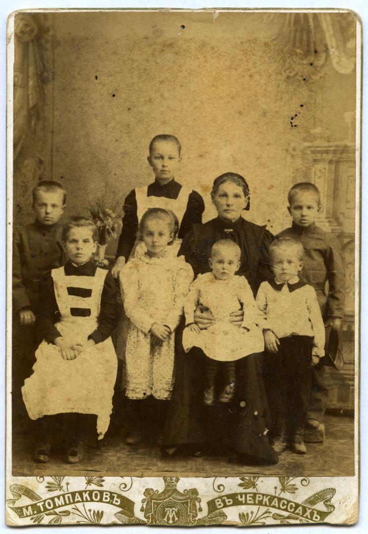 Photo. A woman wearing an urban upper-middle class dress with seven children