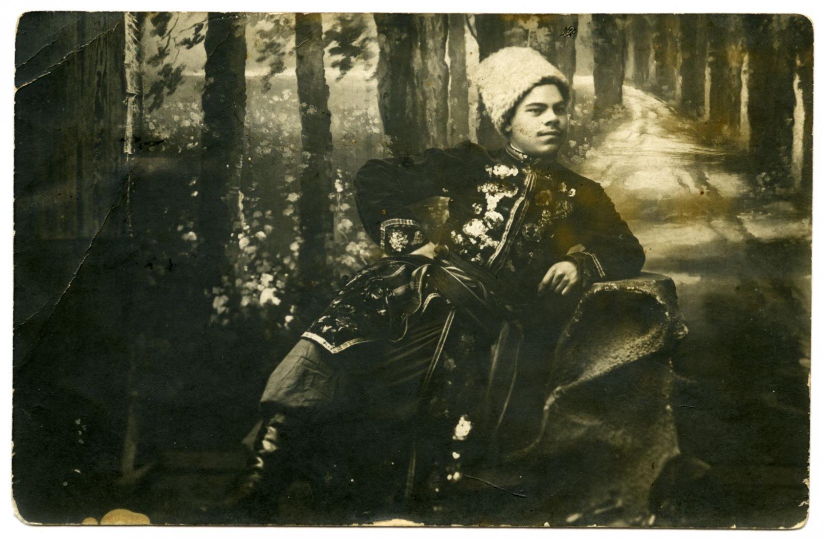 Photo. A guy wearing a stylised Cossack żupan (long overcoat) and a cap