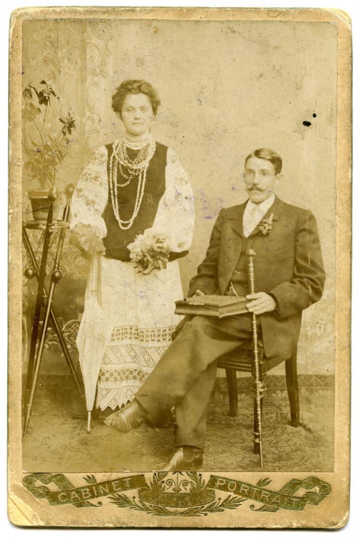 Photo. A young woman wearing an embroidered shirt and a man with a cane