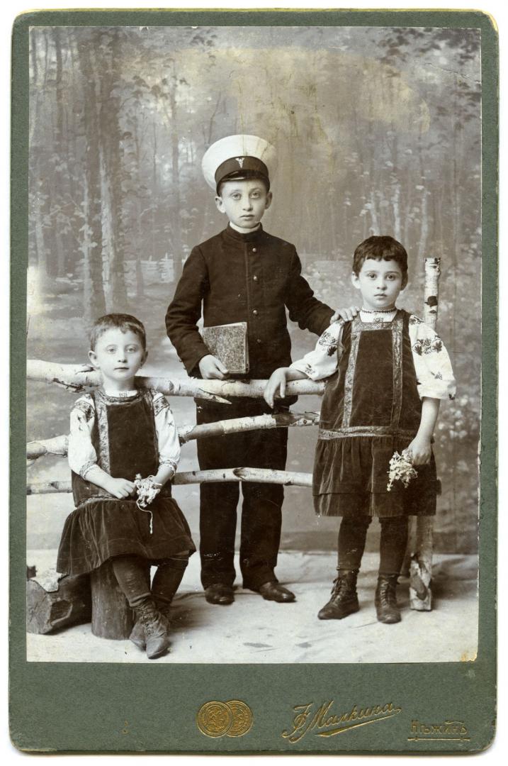 Photo. A boy wearing a highschool uniform and two girls