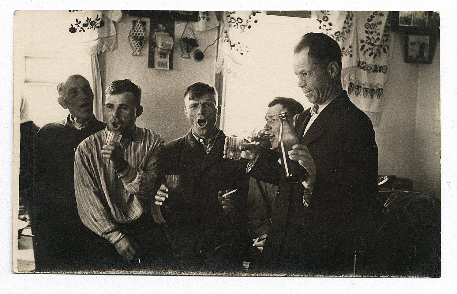 Чоловіки співають під час застілля, образи вбрані вишитими рушниками