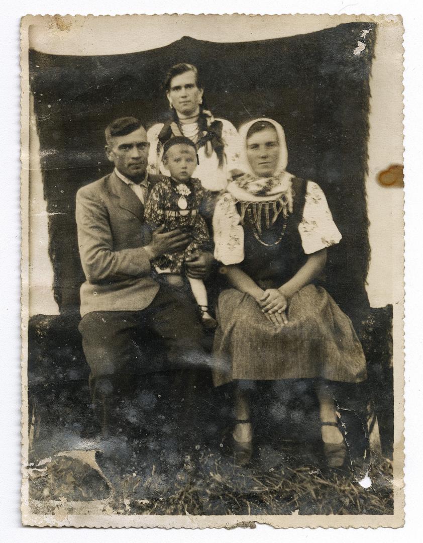 Чоловік з дівчинкою на руках та дві жінки у народному вбранні