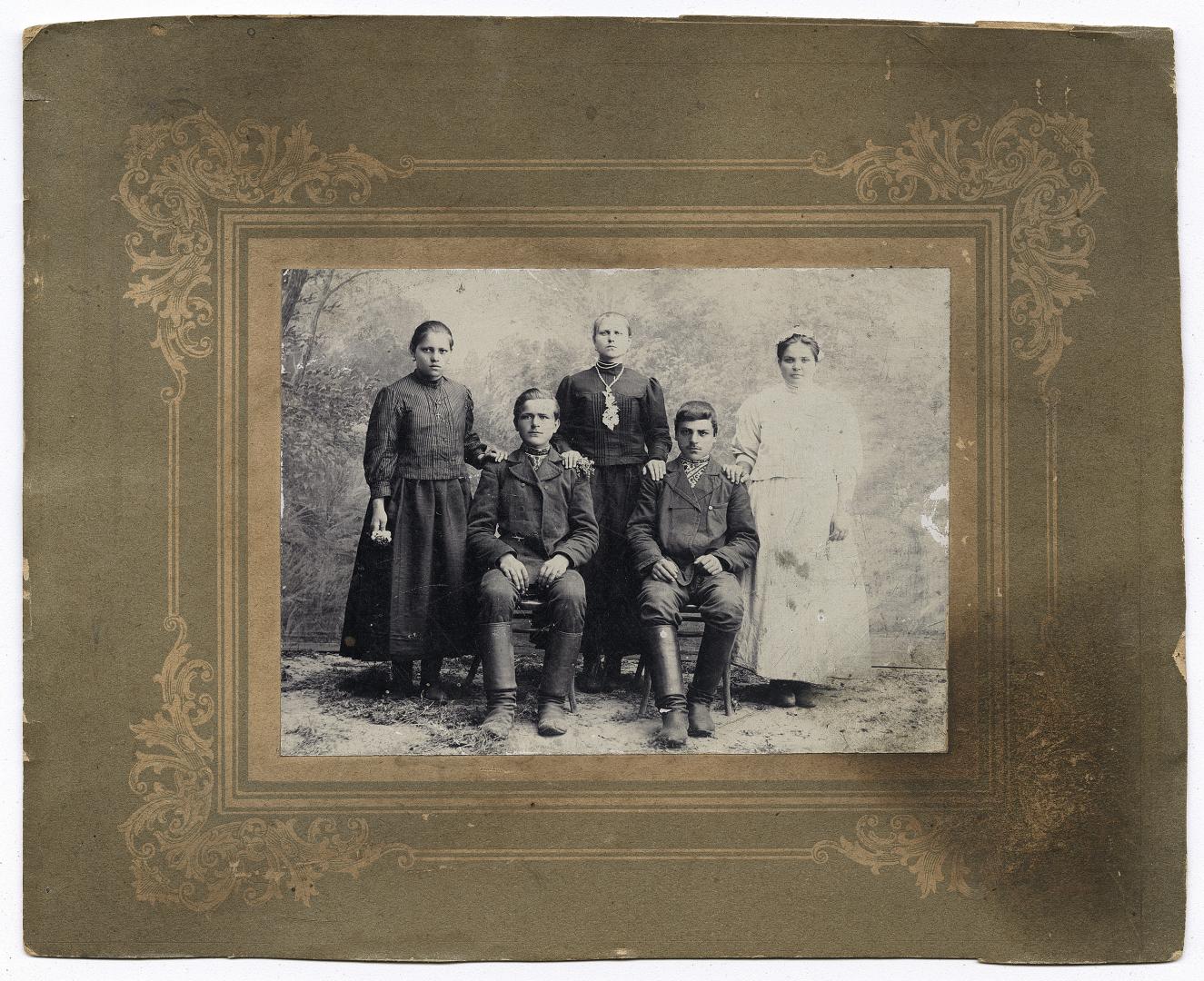 Two boys in embroidered shirts under outerwear and three girls