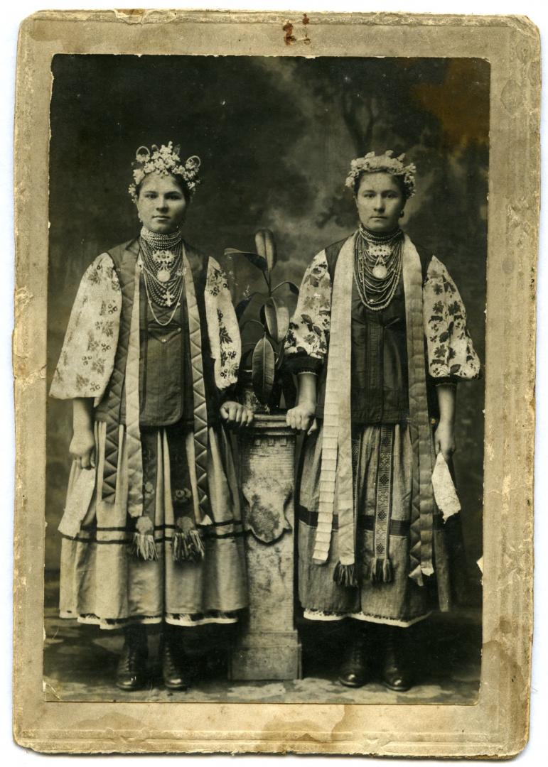 Photo. A bride and her bridesmaid wearing folk attire
